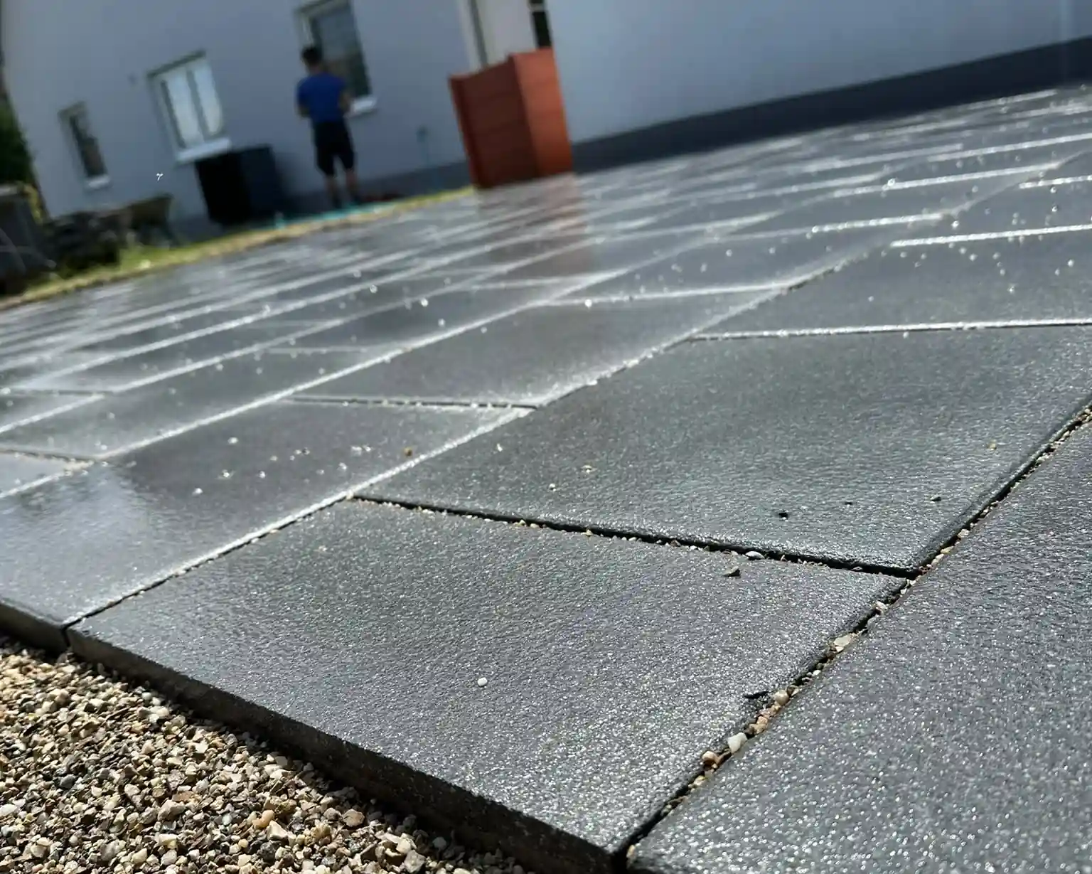 Flacher Blick über frisch verlegte Betonplatten, im Vordergrund die Kiesfuge am Plattenrand