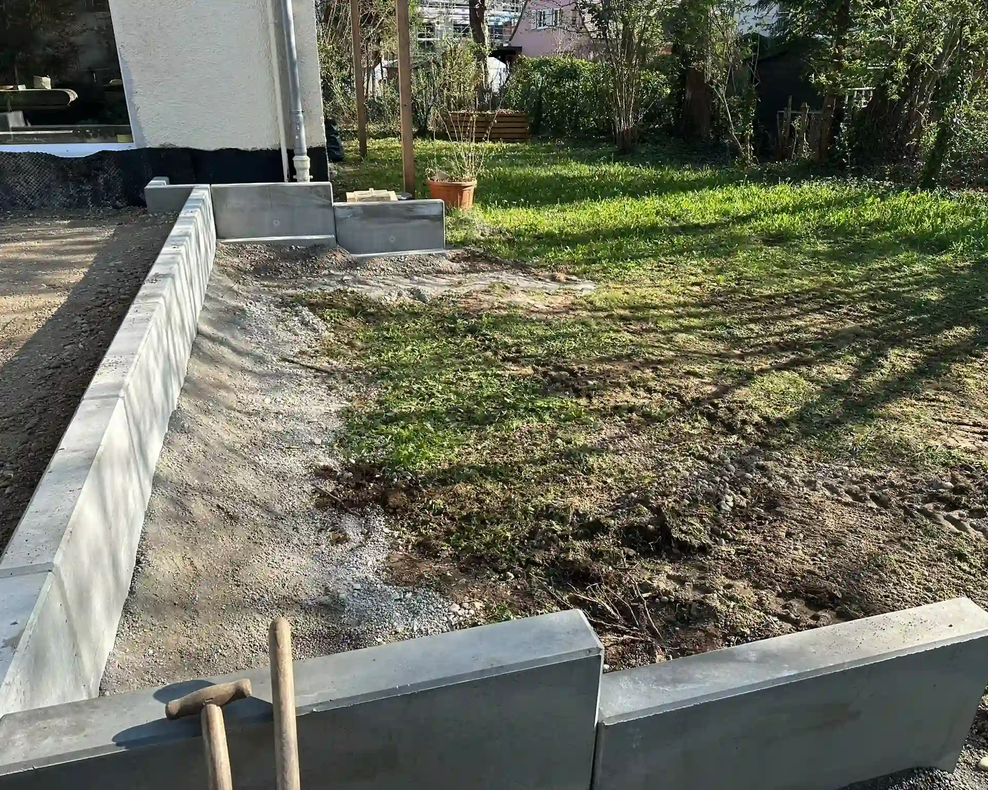 Frisch gesetzte Randsteine bilden die Kante zwischen Rasenfläche und Beet